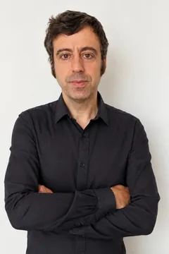 Retrato de Javier García, de brazos cruzados frente a una pared blanca.